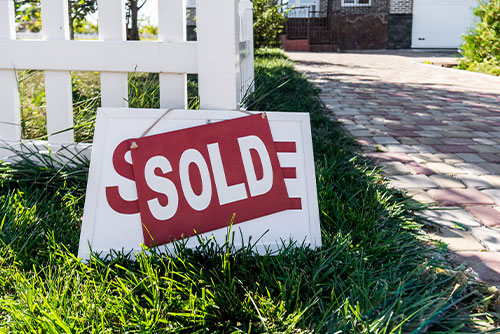 Real Estate sold sign in front yard